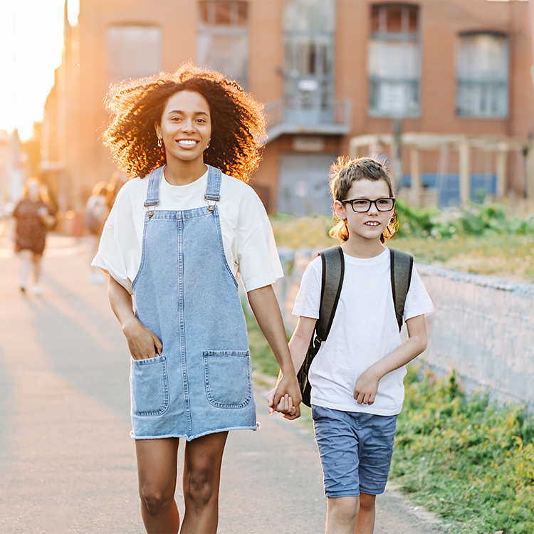 Autism boy with tutor walking back to school outside in sunrise. Autism child and back to school concept